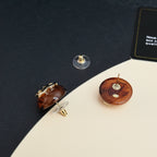 Brown round stud earrings with gold-tone backs and posts, pair displayed