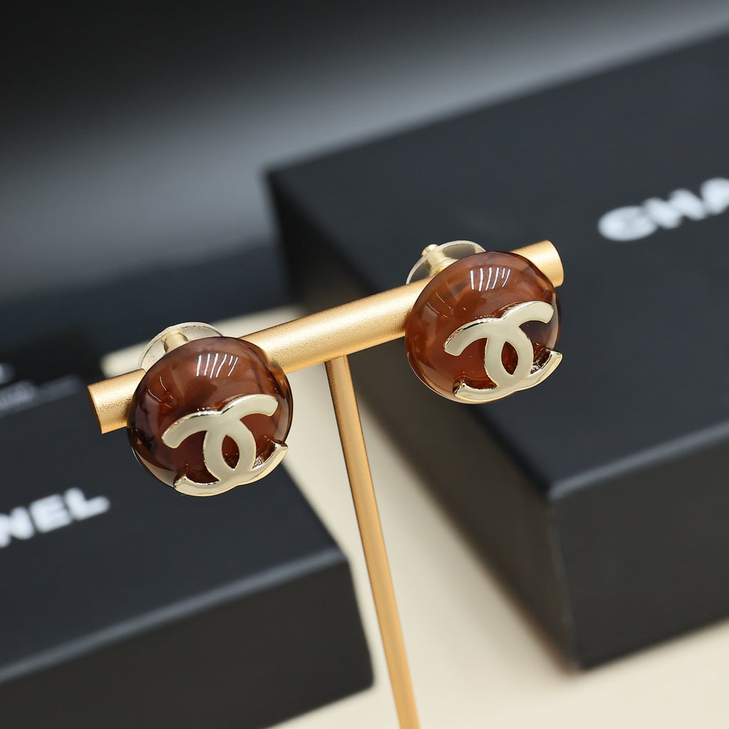 Brown round stud earrings with gold-tone Chanel CC logos on a gold holder