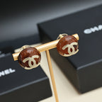 Brown round stud earrings with gold-tone Chanel CC logos on a gold holder