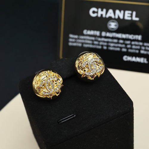Gold-tone stud earrings with round logo design and clear rhinestone details