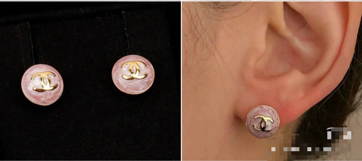 Chanel stud earrings on ear: round pink enamel with gold-tone CC logo