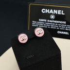 Chanel stud earrings with round pink enamel, gold-tone CC monogram, on black card