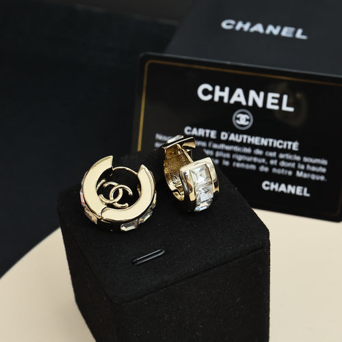 Gold-tone hoop earrings with interlocking logo and clear rhinestone accents