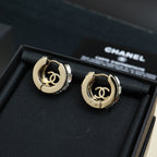 Pair of gold-tone hoop earrings with logo medallion and clear rhinestone details