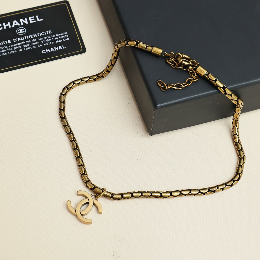 Gold-tone Chanel logo chain necklace laid on gift box