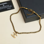 Gold-tone Chanel logo chain necklace laid on gift box