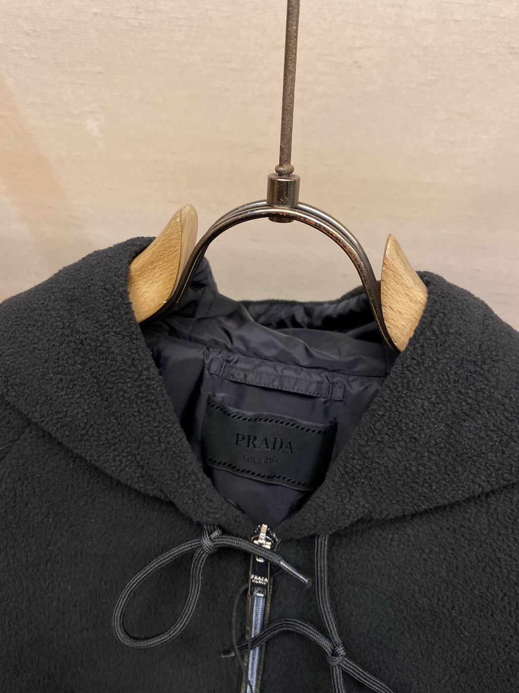 Prada hood lining detail with zipper and interior brand label, dark fabric