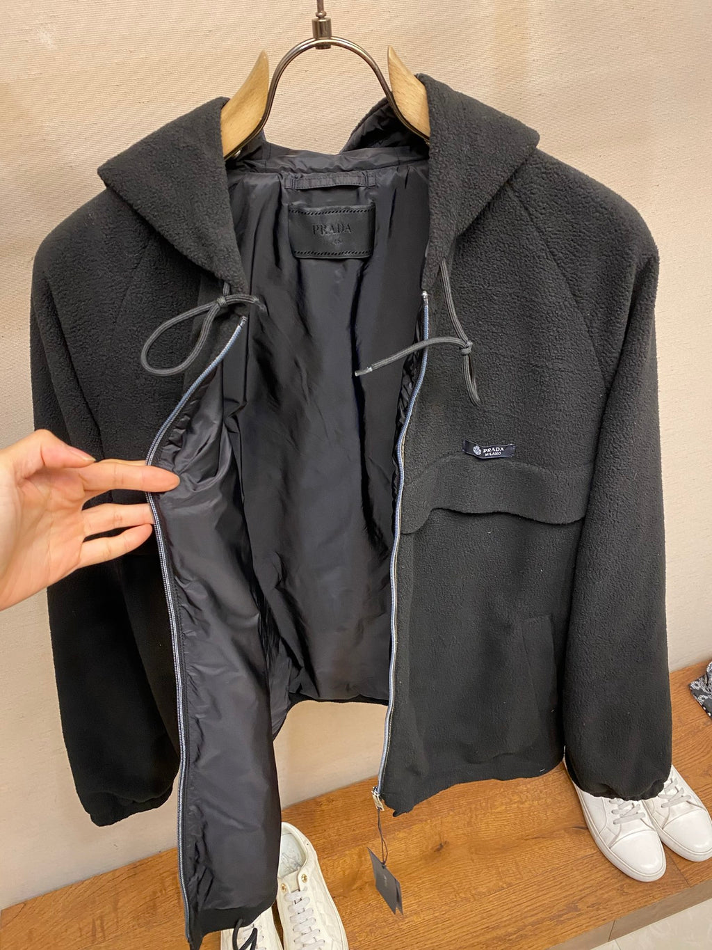 Prada hooded zip jacket open front showing black lining and drawcord details, dark color