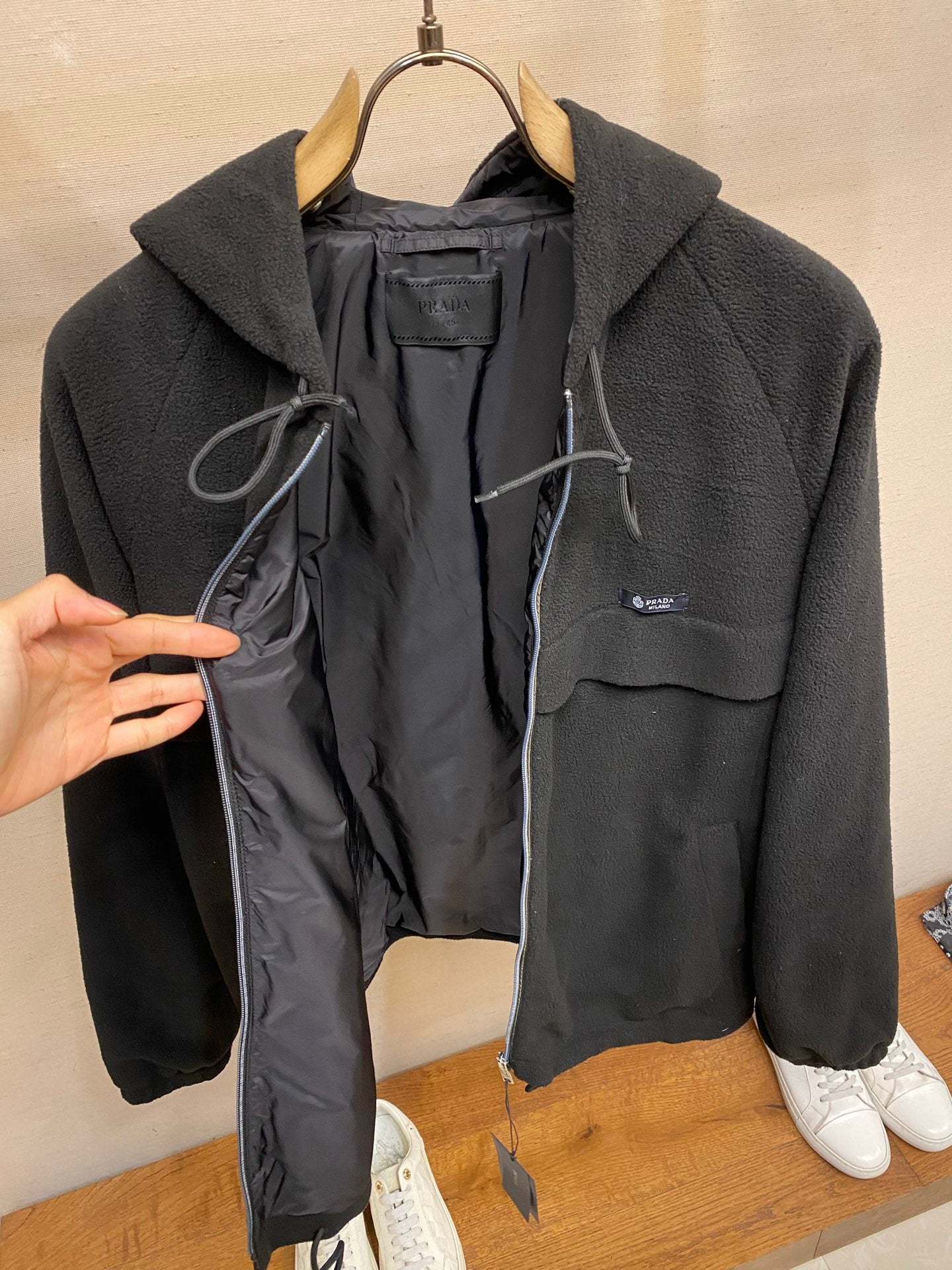 Prada hooded zip jacket open front showing black lining and drawcord details, dark color