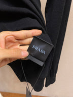 Prada fabric tag attached to dark knit sweater