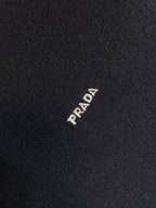 Dark knit sweater fabric with small PRADA logo stitch