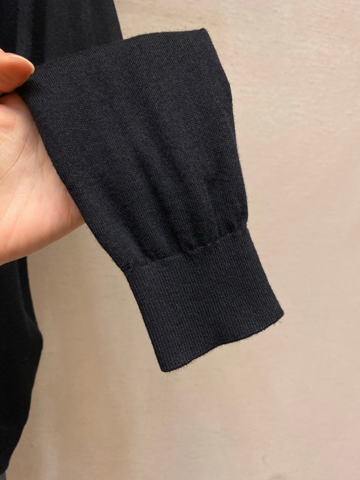 Prada sweater sleeve cuff close-up in dark knit fabric