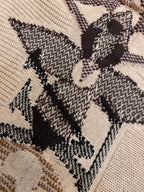 Cream knit sweater fabric with dark and brown jacquard starburst motif