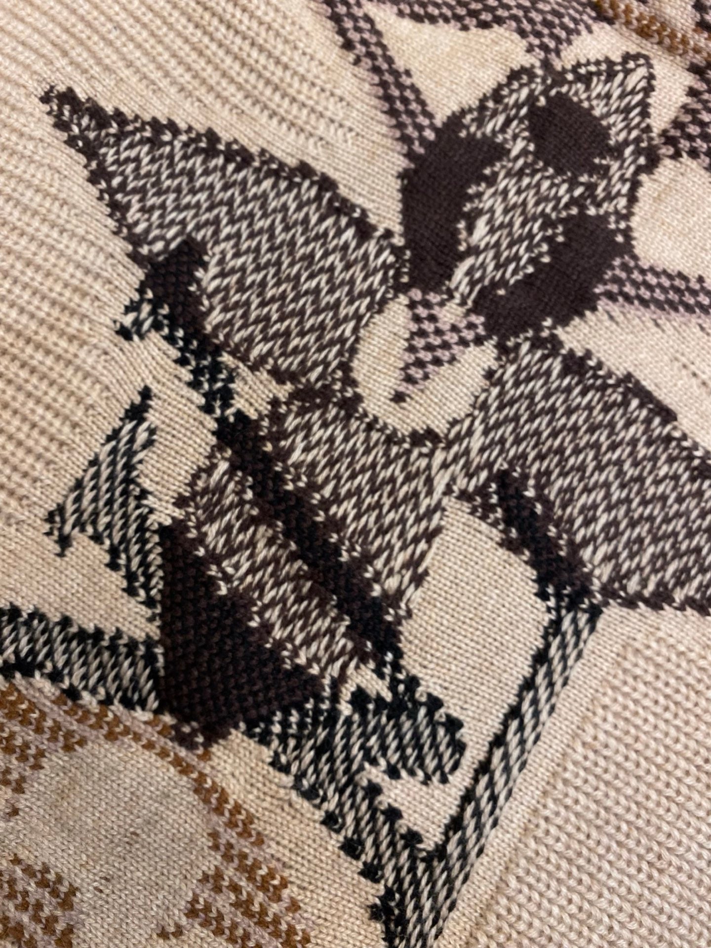 Cream knit sweater fabric with dark and brown jacquard starburst motif