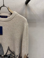 Cream knit sweater with ribbed crew neck and long sleeve, dark jacquard hem motif