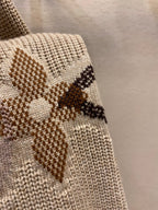 Cream knit sweater sleeve panel with brown and black diamond pattern