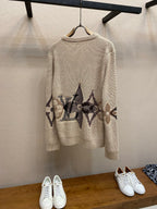 Cream knit crewneck sweater with long sleeves and dark jacquard band graphic on back