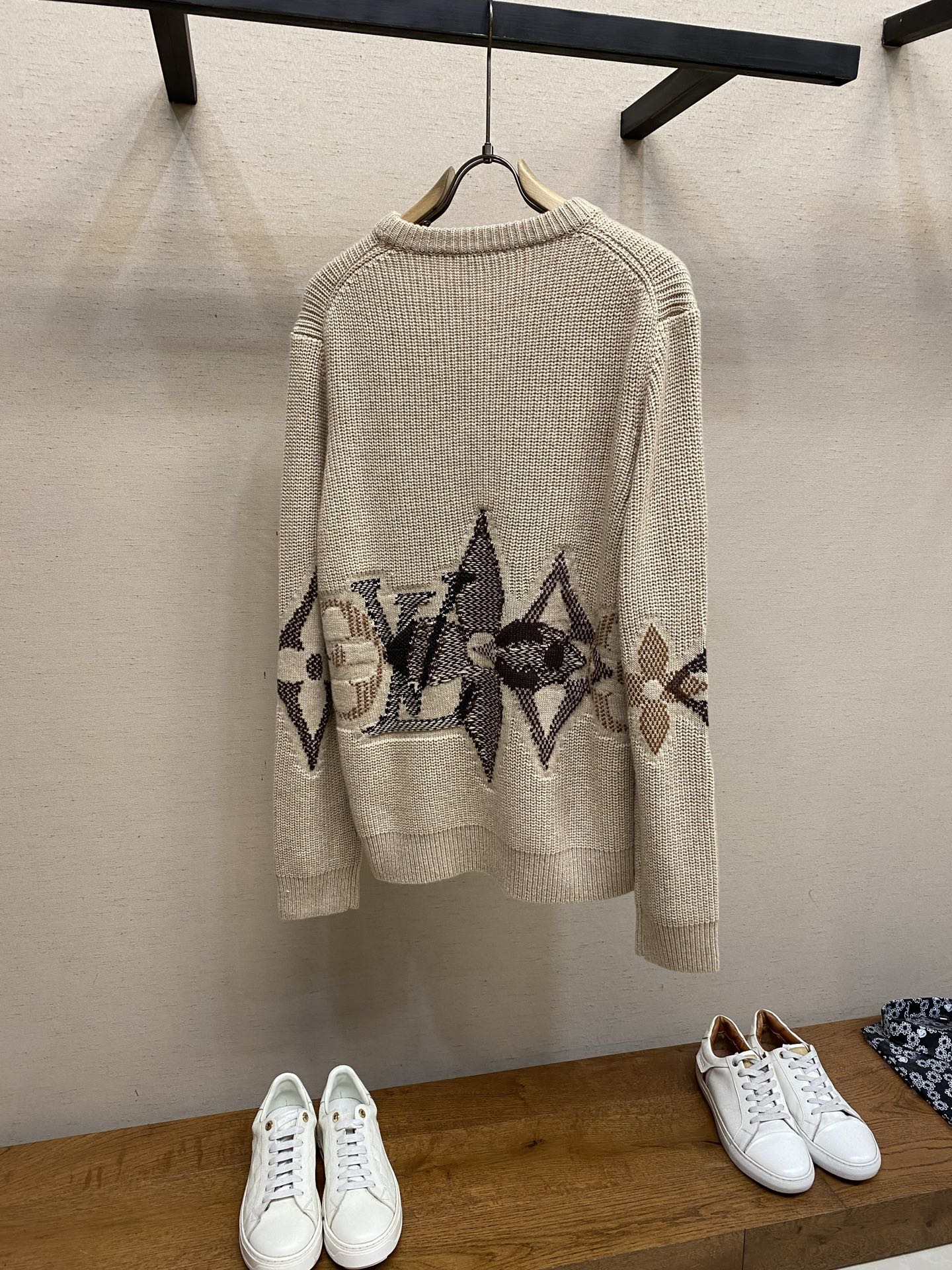 Cream knit crewneck sweater with long sleeves and dark jacquard band graphic on back