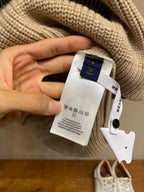 Cream knit sweater with Louis Vuitton care label and size tag attached