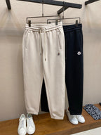 Dark navy Moncler track pants with elastic waistband, drawstring, side logo
