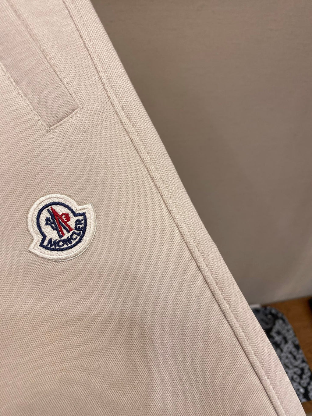 Cream pants leg with small Moncler crest logo patch on side seam