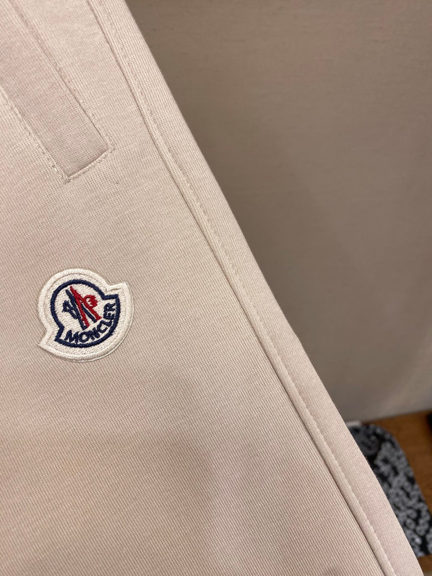 Cream pants leg with small Moncler crest logo patch on side seam