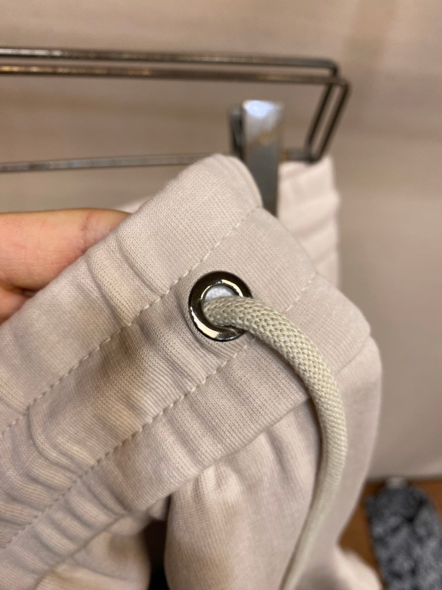 Cream drawstring with metal aglets and stitched waistband loop detail