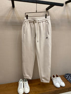 Cream Moncler track pants with elastic waistband and drawstring, front patch pocket