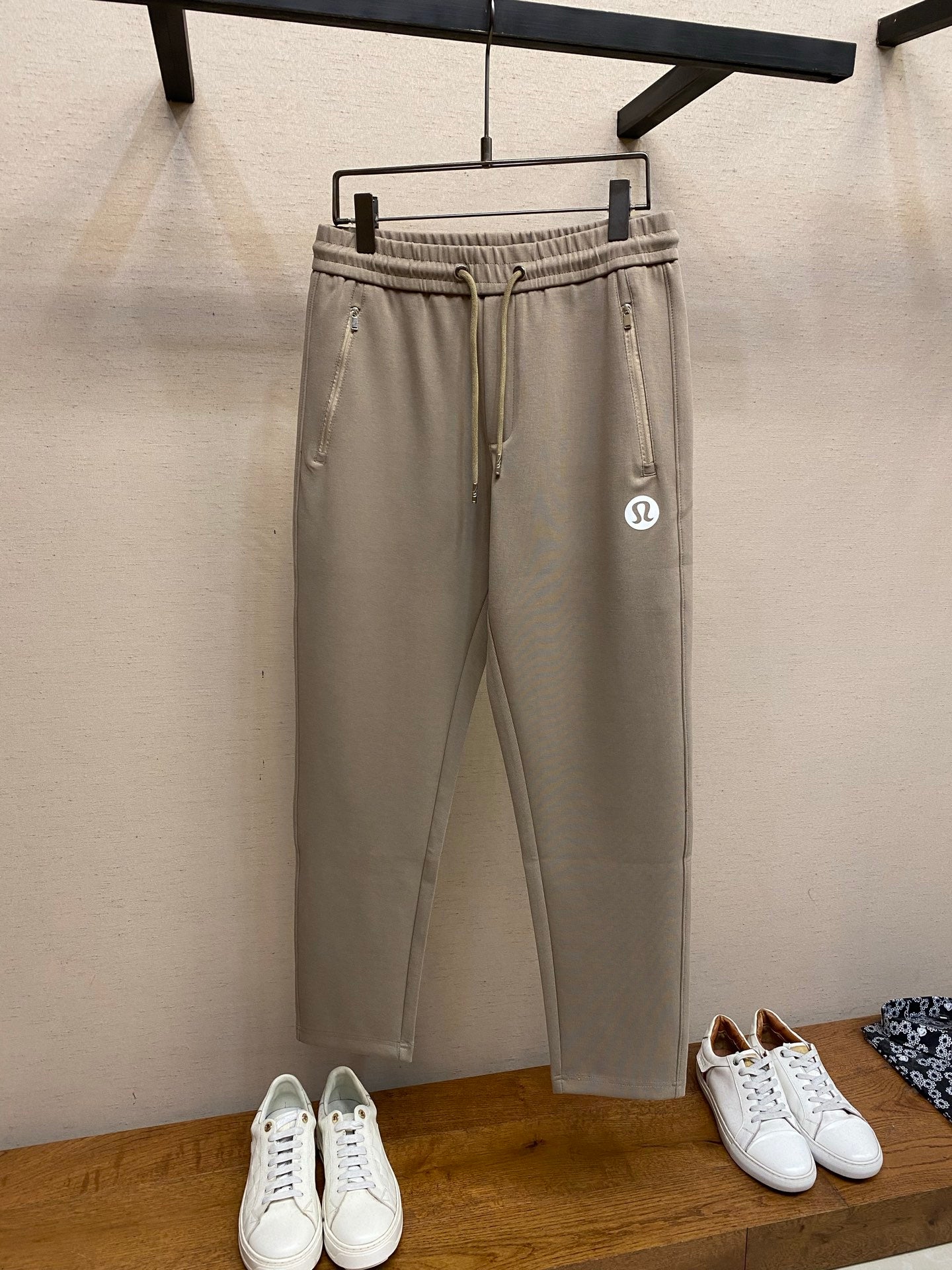 Beige drawstring sweatpants with elastic waistband and side pockets