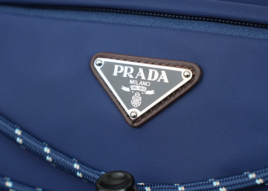 Prada logo triangle plaque on dark-blue nylon bag front