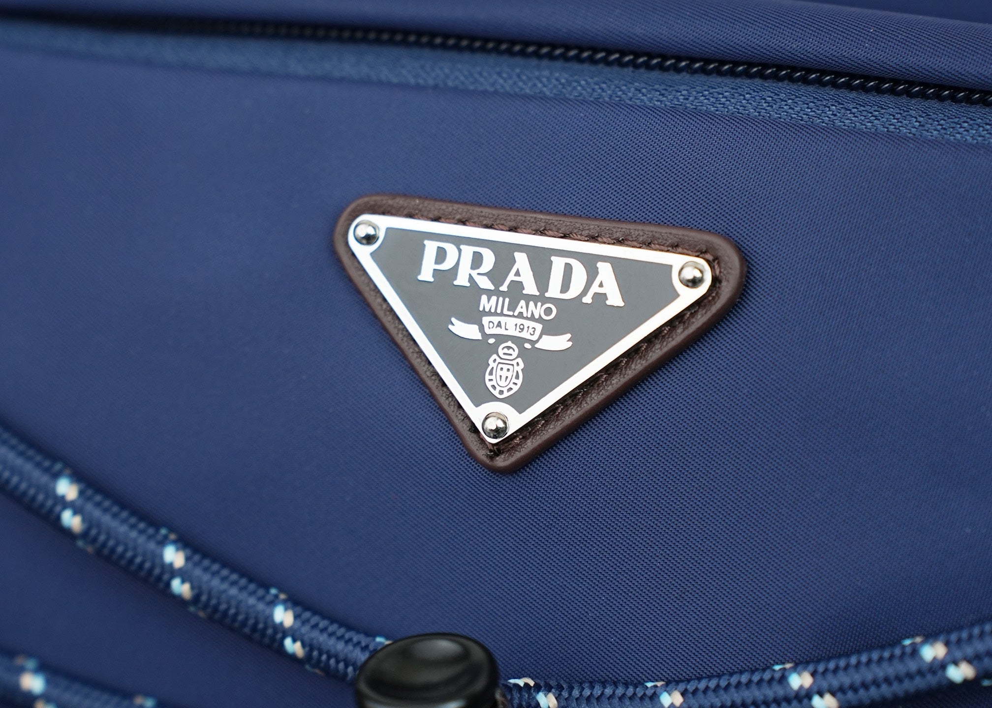 Prada logo triangle plaque on dark-blue nylon bag front