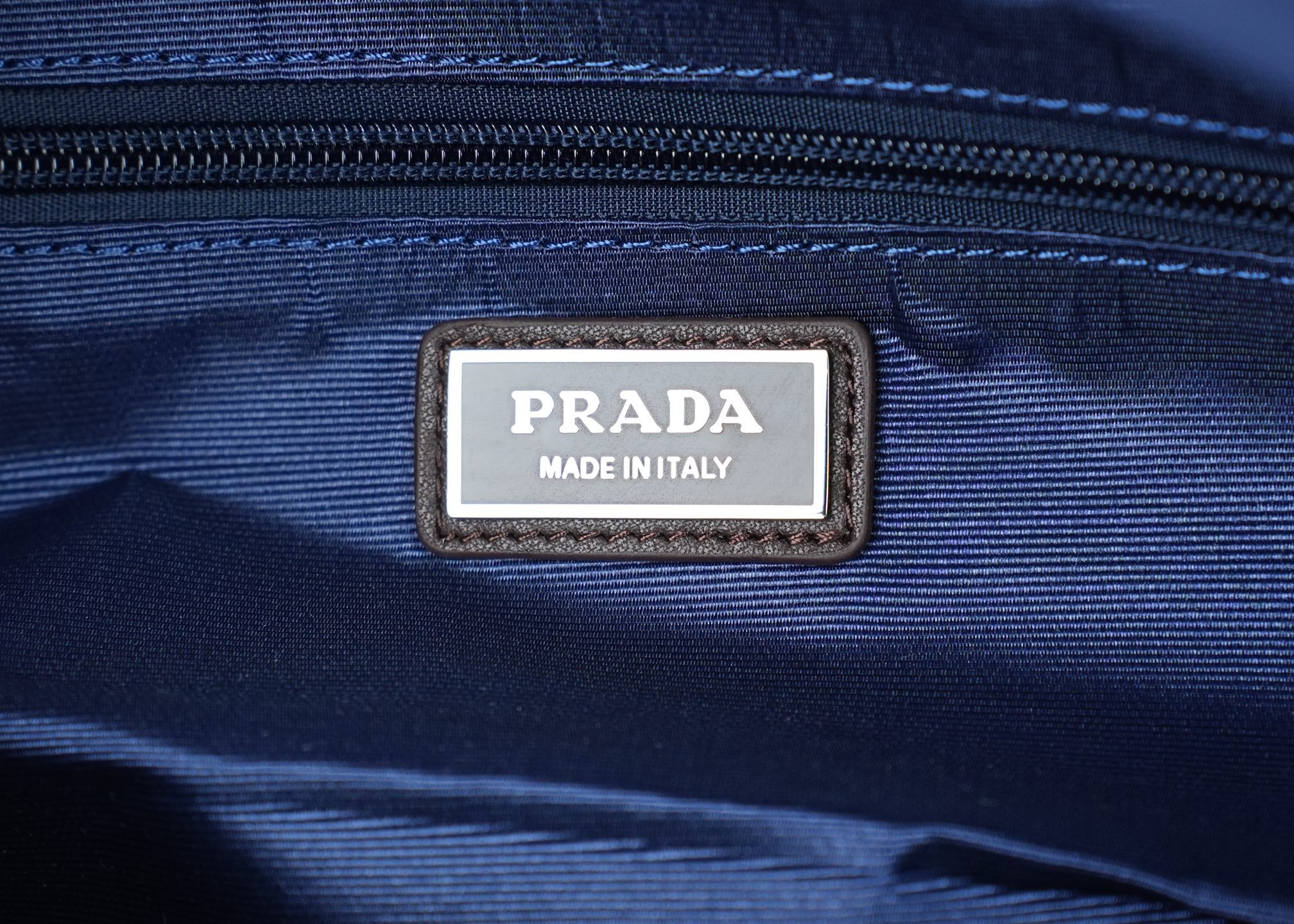Prada Made in Italy leather patch label on dark-blue nylon bag