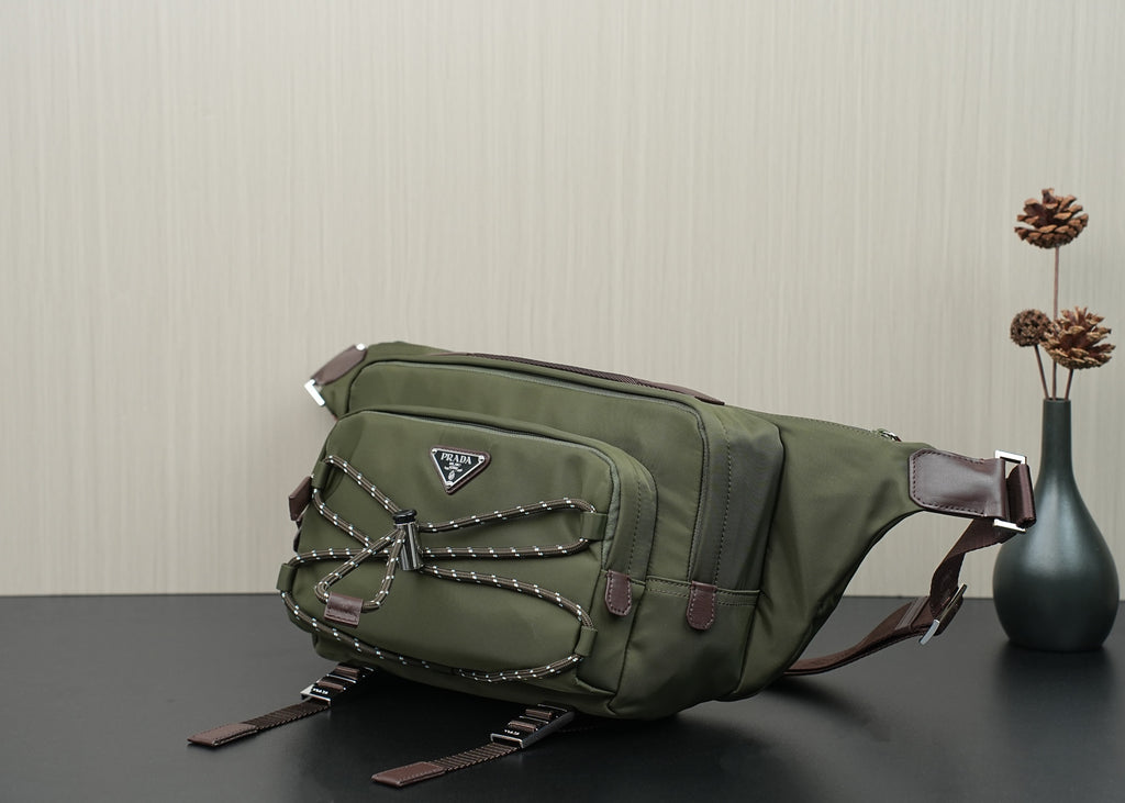 Green Prada bag side view with front patch, stud accents, and adjustable strap ends.