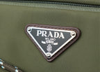Prada Milano logo patch on green fabric with silver metal border and rivets.