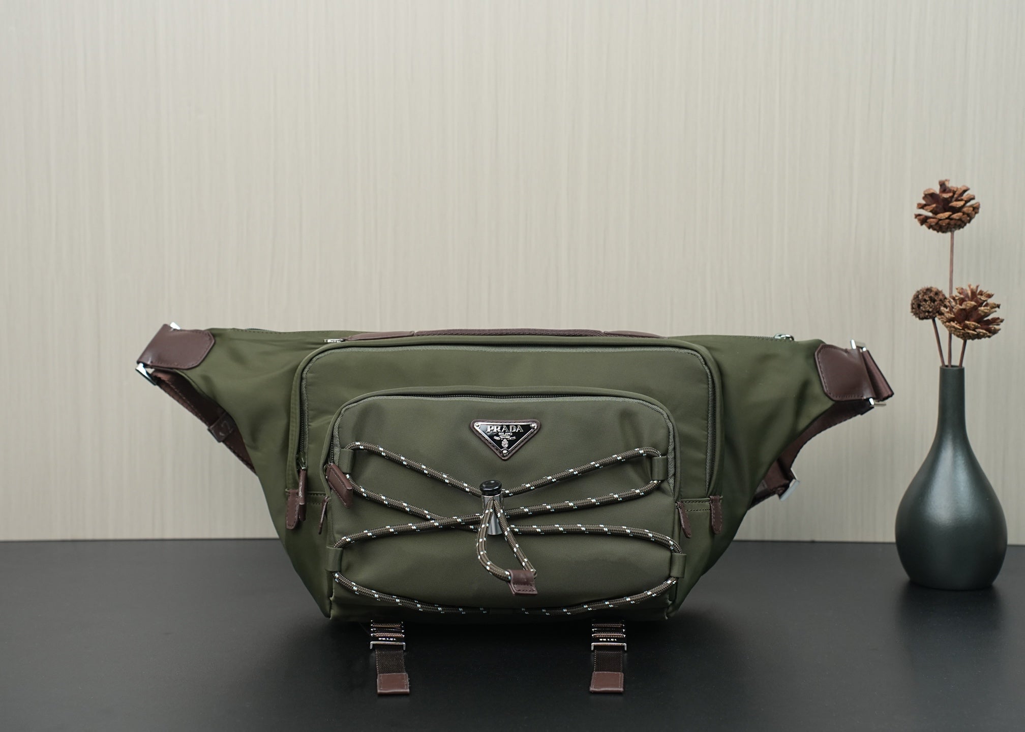Green Prada bag with front logo plaque, quilted strap detail, and zipper closure.