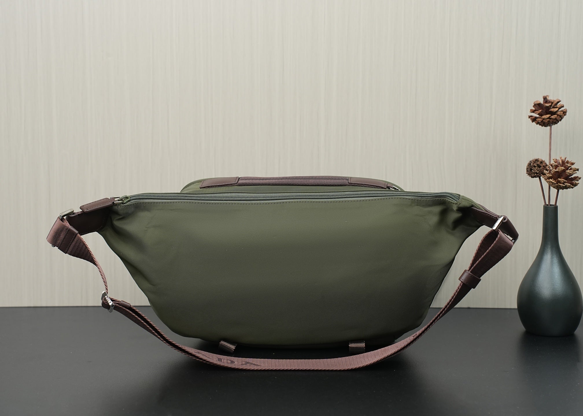 Green Prada bag back view with top handle tabs and zippered back panel.
