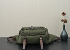 Green Prada bag front-top view with quilted logo panel and two front strap buckles.