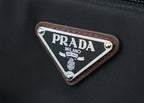 Triangular PRADA logo patch with PRADA MILANO text on brown leather trim.