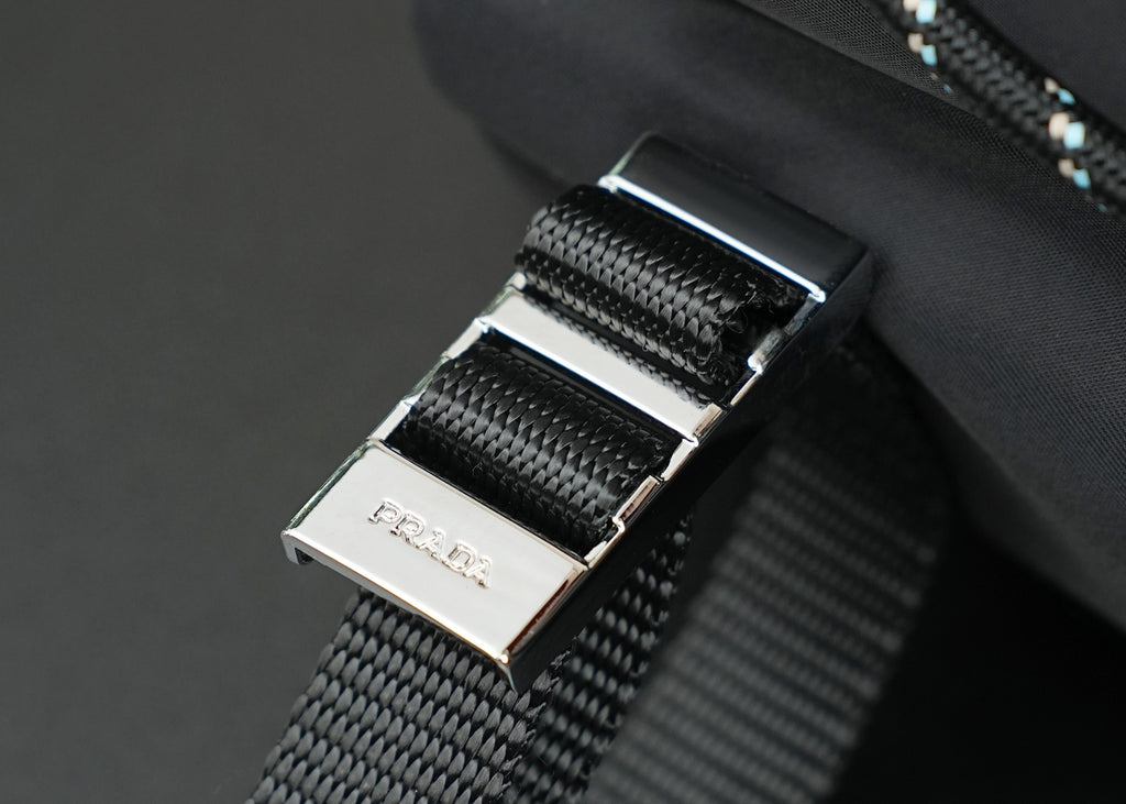 Metal buckle hardware on woven strap with brushed silver accents.