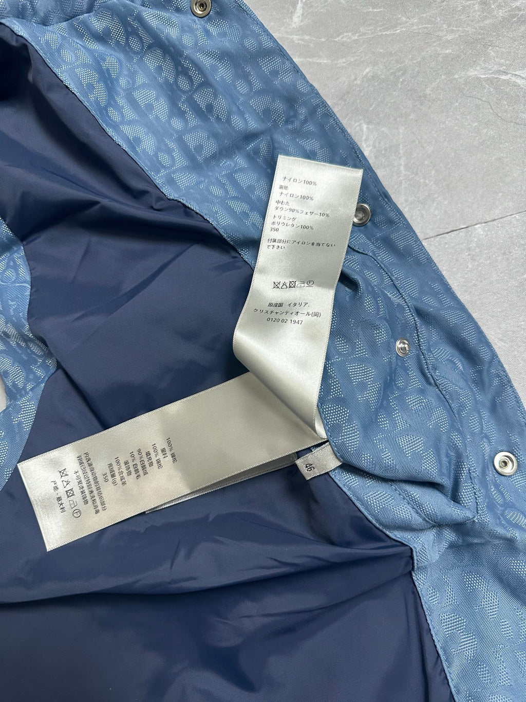 Blue puffer vest with white label tag and snap buttons at shoulder