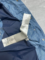 Blue puffer vest with white label tag and snap buttons at shoulder
