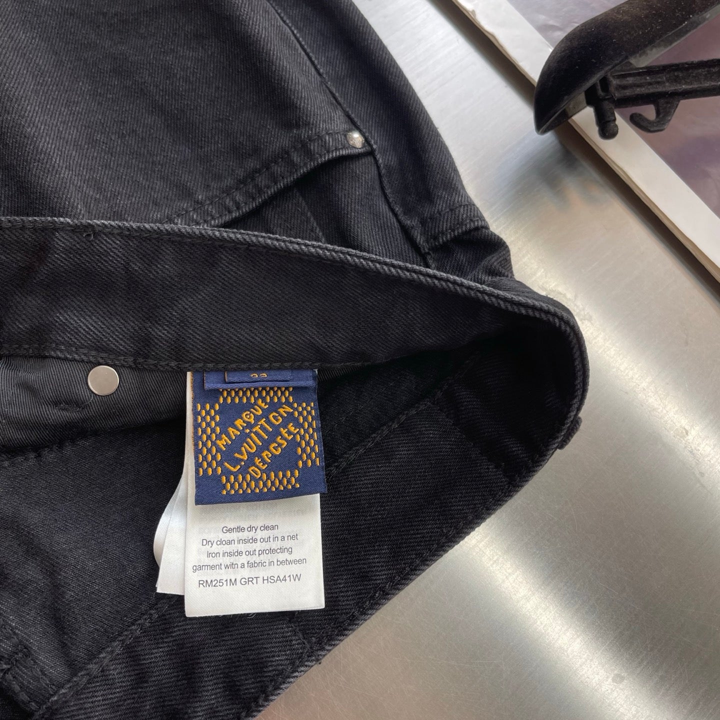 Dark denim pants with care label on the front pocket