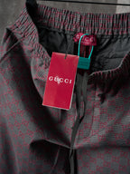 Gucci pants waistband close-up with tags, maroon/gray GG-pattern woven fabric