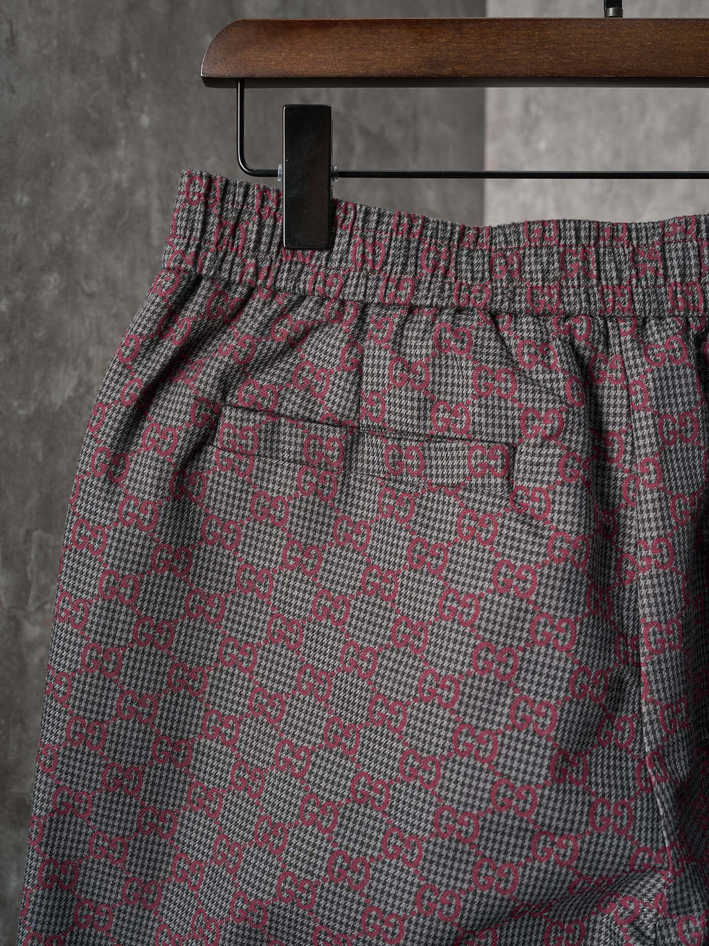 Gucci pants front view with elastic waistband and side pockets, maroon/gray GG-pattern