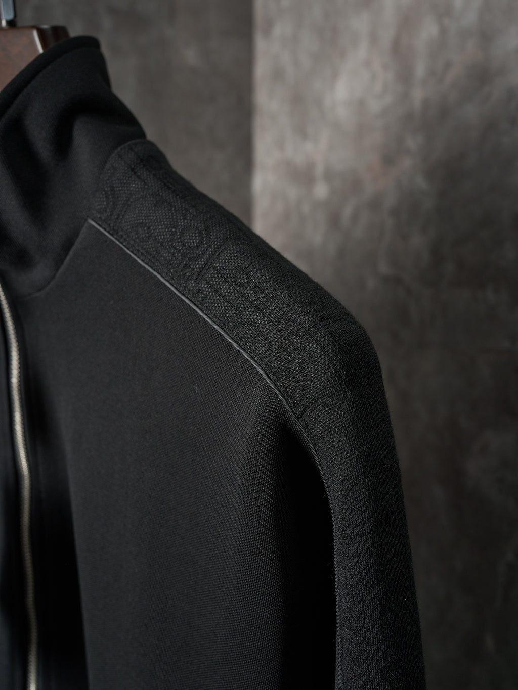 Black Dior jacket shoulder detail with subtle textured fabric finish