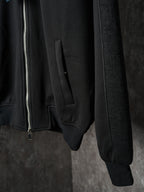 Black Dior zip-up jacket closeup of front pocket and ribbed cuffs