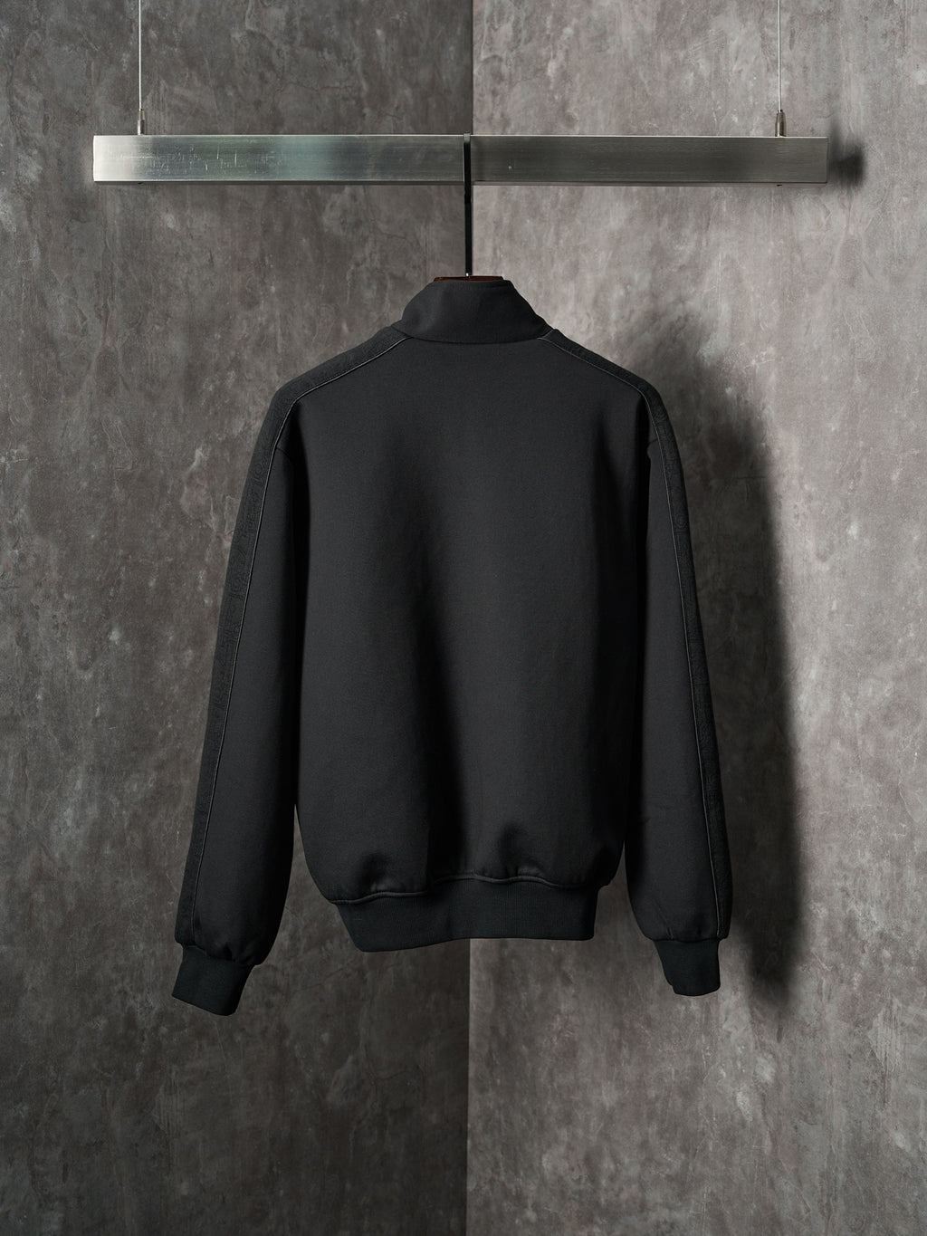 Black Dior zip-up bomber jacket, back view with ribbed hem and cuffs