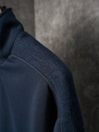 Navy jacket sleeve with textured fabric and stitched shoulder seam