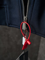 Navy jacket zipper with metal pull and red keyring tag