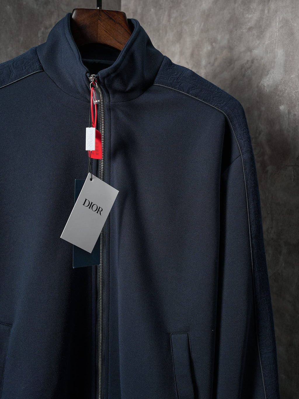 Navy zip-up jacket with stand collar, zipper front, and chest sleeve seam